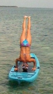 Women performing paddleboard yoga.